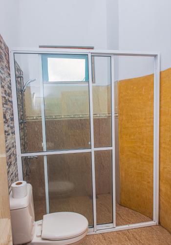 a bathroom with a toilet and a glass shower stall at Ravana Range Ella in Ella