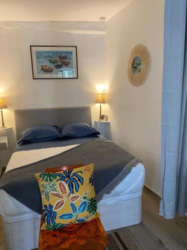 une chambre avec un lit avec des oreillers bleus dans l'établissement Le Joffre - Cosy Studio Cannes Center 3 min walk Palais des Festivals, à Cannes