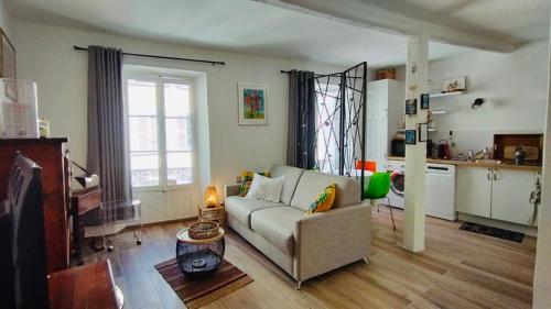 un salon avec un canapé et une cuisine dans l'établissement Le Joffre - Cosy Studio Cannes Center 3 min walk Palais des Festivals, à Cannes