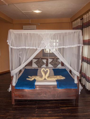 two swans on a bed in a bedroom at Ravana Range Ella in Ella