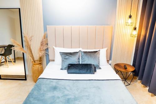 1 dormitorio con 1 cama grande con almohadas azules y blancas en Casa Meraki, en Medellín