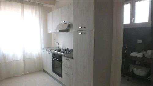 a kitchen with white cabinets and a stove at Dimora Rosantica in Ariano Irpino