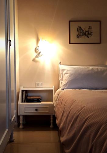 a bedroom with a bed and a light on the wall at Dimora Rosantica in Ariano Irpino