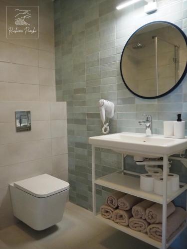 a bathroom with a sink and a toilet and a mirror at Ruchome Piaski in Łeba