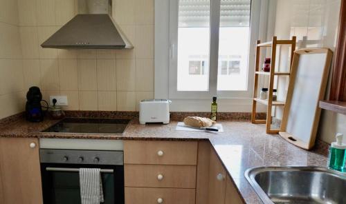 a kitchen with a sink and a stove at Viviendas Margarita II in Colònia de Sant Jordi