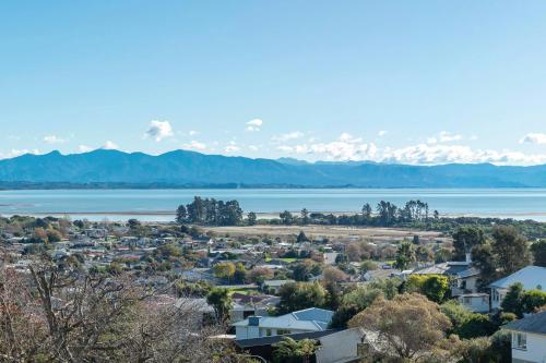a view of a town with a lake and mountains at Blue Water Views in Nelson