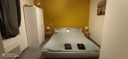 - une chambre dotée d'un lit avec deux objets noirs dans l'établissement Gite MIMOSA, à Baccarat