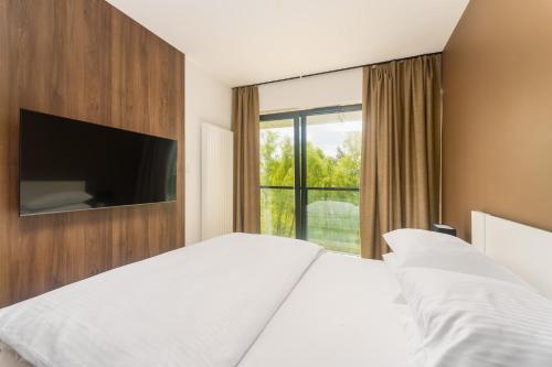 sypialnia z łóżkiem i dużym oknem w obiekcie Apartament Shellter Sun&Sea Rogowo koło Kołobrzegu_Dźwirzyno_nocleg w Rogowie