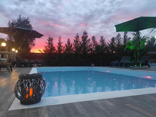 a swimming pool with a sunset in the background at Maia Luxury Pool Villa in Afantou