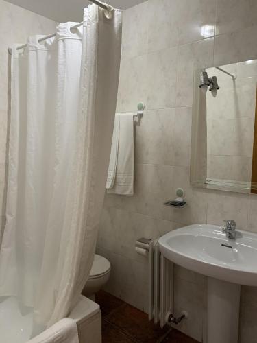 a bathroom with a white shower curtain and a sink at Hostal Atalaya in Capileira