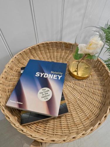 a table with a book and a glass of wine at AZZURRO POD HOTEL - Central Sydney in Sydney