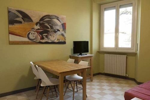 une salle à manger avec une table, des chaises et une télévision dans l'établissement Ospitaci Appartamenti Viale Mezzetti, à Foligno