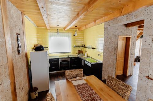a kitchen with a refrigerator and a wooden ceiling at VillaLaylaRostovo in Bugojno
