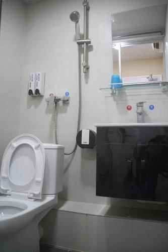 a white bathroom with a toilet and a sink at K & B Hostel in Hong Kong