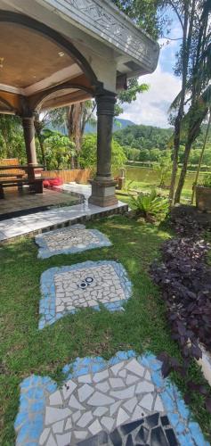 a garden with a stone walkway and a gazebo at Sumatra Cheeky Monkeys in Bukit Lawang