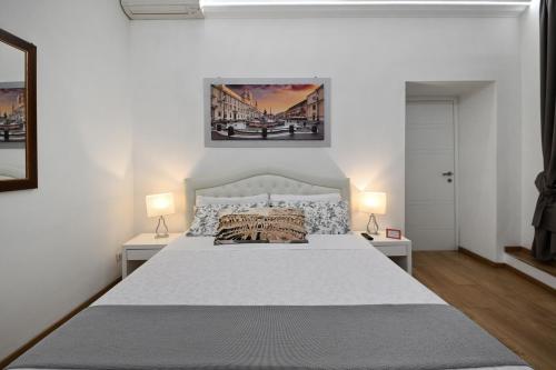 ローマにあるイル ファッシノ ディ ローマのベッドルーム(白い大型ベッド、ランプ2つ付)