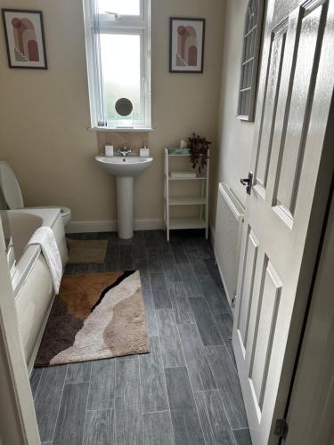 een badkamer met een wastafel, een bad en een wastafel bij Safari Avenue one Bedroom Apartment in Stapleford