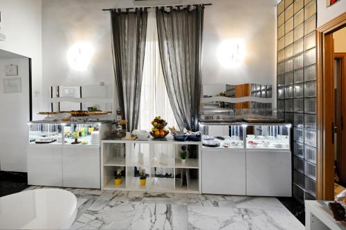 eine Küche mit weißen Arbeitsflächen und einem Fenster in der Unterkunft Il Fascino Di Roma in Rom