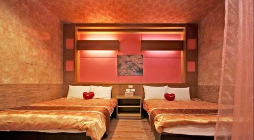 two beds in a room with red walls at 日月潭 -日月住館-休閒旅館- 水社碼頭 in Yuchi