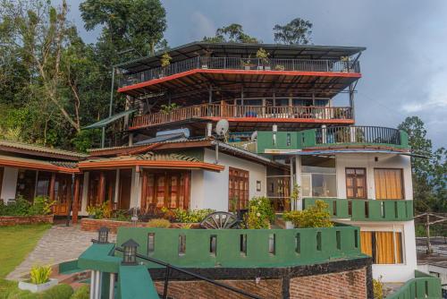 a large house with a green balcony at Ravana Range Ella in Ella