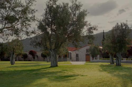 a house with trees in front of a yard at Zaira Hotel in Skála Loutrón