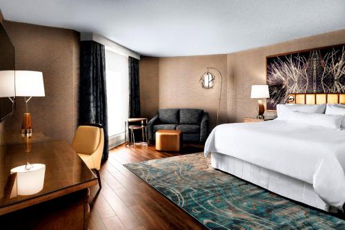 a bedroom with a bed and a desk and a chair at The Westin Toronto Airport in Toronto