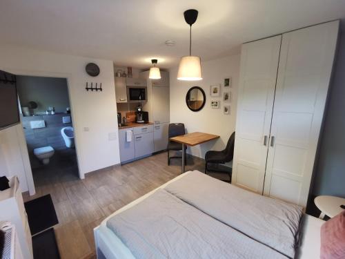 a bedroom with a bed and a desk and a kitchen at Apartment Maiglöckchen in Fritzlar