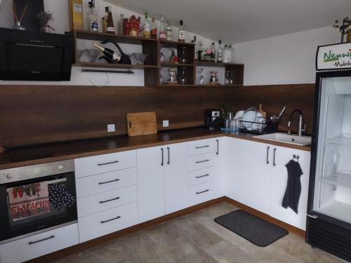 een keuken met witte kasten en een wastafel bij Къща за гости Вила Победа 