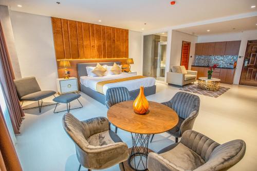 Solano Hotel في ليبا: غرفة فندقية بسرير وطاولة وكراسي