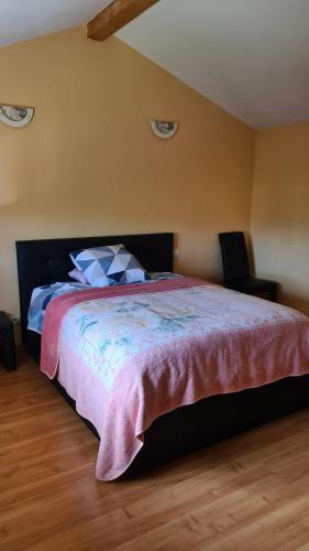 a bedroom with a large bed with two chairs at Maison au calme in Sainte-Marguerite