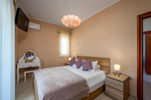 - une chambre avec un lit, une télévision et une table dans l'établissement Sunny Garden Apartments, à Pastida