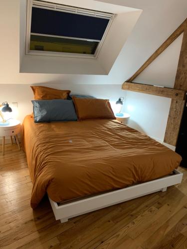 a bedroom with a large bed with two night stands at Le 24’ Chrono in Le Mans