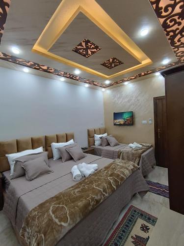 two beds in a room with a ceiling at Petra downtown house in Wadi Musa