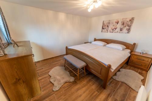 Schlafzimmer mit einem Bett und Holzboden in der Unterkunft Hill Cottage Haloze in Gruškovec