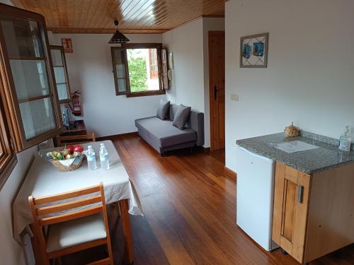 eine Küche und ein Wohnzimmer mit einem Tisch und einem Sofa in der Unterkunft Mar Tu Apartamento en Llanes in Llanes