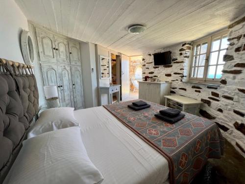 a bedroom with a bed and a tv in it at The Stone Windmill in Koundouros