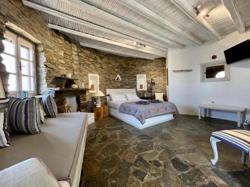 a bedroom with a bed and a stone wall at The Stone Windmill in Koundouros