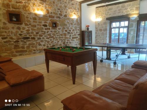 ein Wohnzimmer mit einem Billardtisch und Tischtennisplatten in der Unterkunft Les colombages in Pazayac