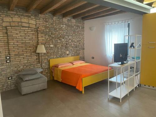 a bedroom with a bed in a brick wall at Casa Fabbro in Palazzolo dello Stella