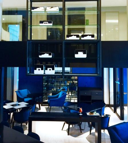 a restaurant with blue chairs and tables and windows at Astoria Greenbelt in Manila