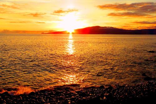 una puesta de sol en la orilla de un cuerpo de agua en Casa do Cais, en Monte