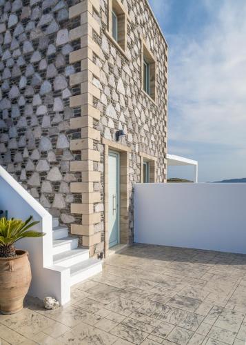 a brick building with a white sign on the side of it at Thea Sunset Suites in Mytakas