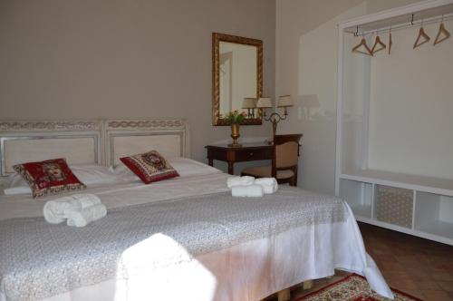 1 dormitorio con cama blanca y espejo en Uzeda, Doppia con bagno privato en Mascalucia