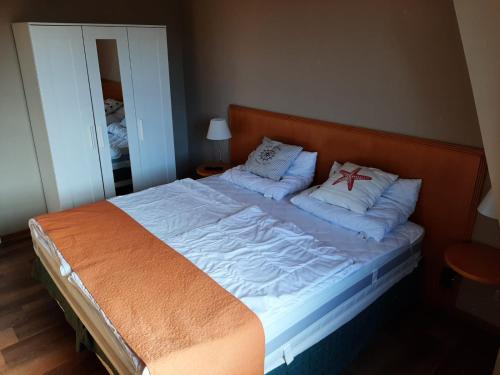 uma cama grande num quarto com duas almofadas em FeWo Windsbraut im Landhaus Immenbarg em Rostock