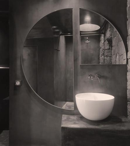 a bathroom with a white sink and a mirror at Serra Exclusive Suites in Akrotiri