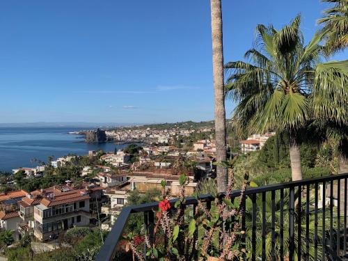 a view of a city and the ocean from a balcony at Casa Nausica in Acitrezza