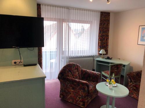 a living room with a chair and a table at Hotel Weisses Lamm in Allersberg