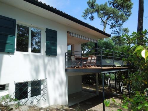 une maison avec un balcon sur le côté dans l'établissement Floc de bruc - Hossegor belle villa moderne à seulement quelques pas du lac, à Soorts-Hossegor