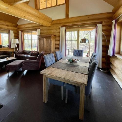 a living room with a wooden table and a couch at Unieke houten villa met SAUNA in Twente - 5p in Den Ham