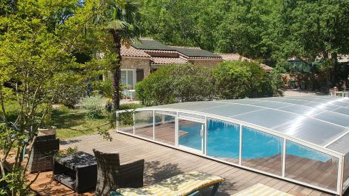 a swimming pool with a tennis court next to a house at Villa Eden Vert in Fayence